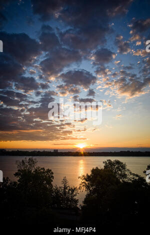 Der Sonnenaufgang bricht den Horizont und spiegelt sich am Lake Calhoun in Minneapolis, Minnesota, wider. Stockfoto