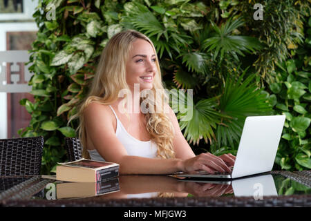 Junge kaukasier Frau Backpacker eine weiße Weste top und sitzen an einem Tisch in Asien, der an einem Notebook arbeitet, Vietnam, Indochina, Südostasien, Asien Stockfoto