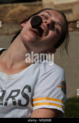 Eine junge Frau versucht, vorsichtig ein Oreo Cookie aus der Stirn in ihren Mund bewegen, in Atlanta Field Day am 16 Juli, 2016 in Atlanta, GA. Stockfoto