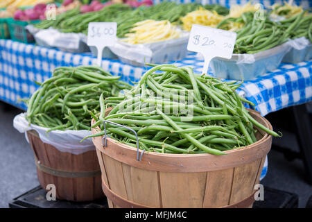 Ein scheffel Bohnen neben einem blauen Tischdecke auf ein Bauernmarkt überprüft. Stockfoto