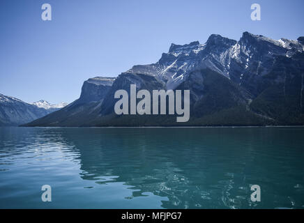 Die hochfliegende Kanadischen Rocky Mountains stand oberhalb der felsigen Küste des Lake Minnewanka in der Nähe von Banff, Alberta, Kanada Stockfoto