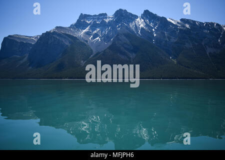 Die hochfliegende Kanadischen Rocky Mountains stand oberhalb der felsigen Küste des Lake Minnewanka in der Nähe von Banff, Alberta, Kanada Stockfoto