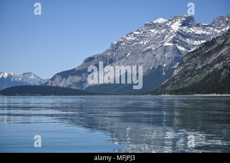 Die hochfliegende Kanadischen Rocky Mountains stand oberhalb der felsigen Küste des Lake Minnewanka in der Nähe von Banff, Alberta, Kanada Stockfoto