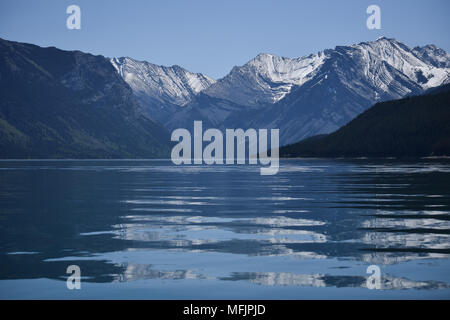 Die hochfliegende Kanadischen Rocky Mountains stand oberhalb der felsigen Küste des Lake Minnewanka in der Nähe von Banff, Alberta, Kanada Stockfoto