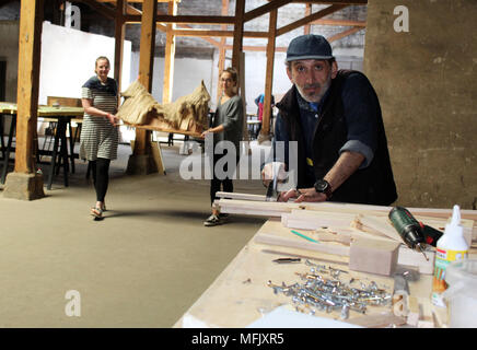 23 April 2018, Deutschland, Görlitz: Hussein vuilding Daowdi aus Syrien ein Modell für die Goerlitz Viertel an der Ausstellung 'Weltstadt' (lit. world city) und im Hintergrund die Studenten Michaela Krauss (L) und Josephine Junker. Foto: Miriam Schönbach/dpa-Zentralbild/dpa Stockfoto