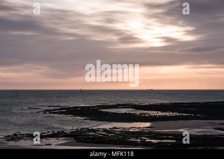 Dunstanburgh Castle, Northumberland. 26. April 2018. Die Sonne verschwindet hinter Wolken über Embleton Bay Credit: Dan Cooke Credit: Dan Cooke/Alamy leben Nachrichten Stockfoto