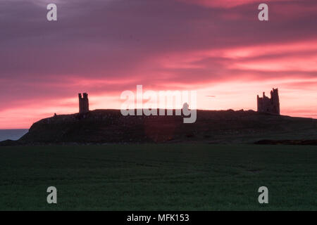 Dunstanburgh Castle, Northumberland. 26. April 2018. Die Sonne geht hinter Dunstanburgh Castle an einem bewölkten Tag. Credit: Dan Cooke Credit: Dan Cooke/Alamy leben Nachrichten Stockfoto