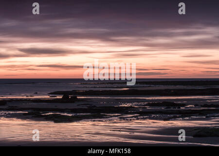 Dunstanburgh Castle, Northumberland. 26. April 2018. Dawn beginnt bei Embleton Bucht an einem bewölkten Morgen Credit: Dan Cooke Credit: Dan Cooke/Alamy leben Nachrichten Stockfoto