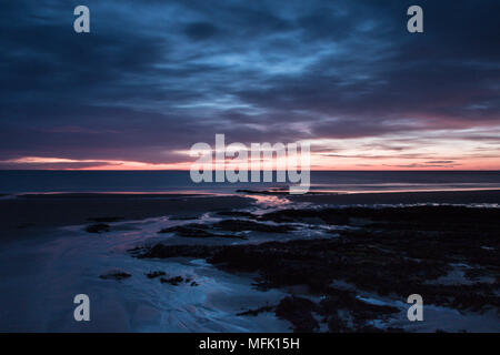 Dunstanburgh Castle, Northumberland. 26. April 2018. Dawn beginnt bei Embleton Bucht an einem bewölkten Morgen Credit: Dan Cooke Credit: Dan Cooke/Alamy leben Nachrichten Stockfoto