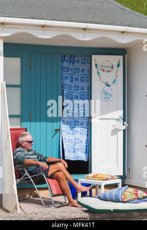 Bournemouth, Dorset, Großbritannien. 26. April 2018. UK Wetter: sonnig und windig in Bournemouth. Mann Entspannung am Strand Hütte am Alum Chine. Credit: Carolyn Jenkins/Alamy leben Nachrichten Stockfoto