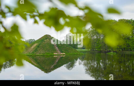 Cottbus, Deutschland. 26. April 2018, Cottbus, Deutschland: Sea Pyramide im Fürst-Pückler-Park Branitz bei Cottbus im Wasser spiegelt. Reparaturarbeiten haben unterwegs am Wasser Pyramide im Branitzer Park seit einigen Tagen. Auf dem hügelgrab im Juni 2017, hatte es ein Spülen aus dem Bewässerungssystem. Die Treppe Abschnitt wird nun verlegt werden. Anfang März, nach einer Brandstiftung, Gas und Pflanzen waren auf der Pyramide verbrannt. Patrick Quelle: dpa Picture alliance/Alamy leben Nachrichten Stockfoto