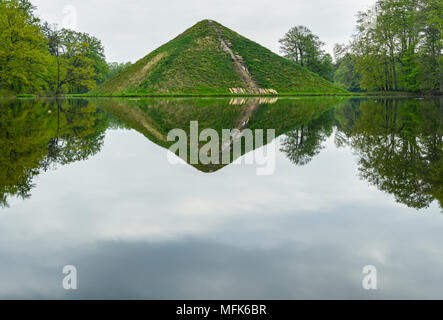 Cottbus, Deutschland. 26. April 2018, Cottbus, Deutschland: Sea Pyramide im Fürst-Pückler-Park Branitz bei Cottbus im Wasser spiegelt. Reparaturarbeiten haben unterwegs am Wasser Pyramide im Branitzer Park seit einigen Tagen. Auf dem hügelgrab im Juni 2017, hatte es ein Spülen aus dem Bewässerungssystem. Die Treppe Abschnitt wird nun verlegt werden. Anfang März, nach einer Brandstiftung, Gas und Pflanzen waren auf der Pyramide verbrannt. Patrick Quelle: dpa Picture alliance/Alamy leben Nachrichten Stockfoto