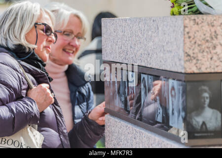 London, Großbritannien. 26 Apr, 2018. Touristen werden durch die Bilder von anderen Aktivisten rund um den Sockel - 8 ft 4 in Bronze Statue Der suffragist Mitkämpfer Millicent Fawcett jetzt im Schatten der Häuser des Parlaments ist nach einer Kampagne geführt von Criado-Perez intrigiert. Es wurde von Turner Prize-winning artist Gillian Wearing und zeigt Fawcett, als Sie Präsident der Nationalen Union der Frauenwahlrecht Gesellschaften wurde. Credit: Guy Bell/Alamy leben Nachrichten Stockfoto