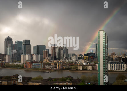 London, Großbritannien. 26. April 2018. UK Wetter: Ein Regenbogen bricht über East London einschließlich Canary Wharf business park Gebäude während eines kurzen Nachmittag Regensturm. © Guy Corbishley/Alamy leben Nachrichten Stockfoto