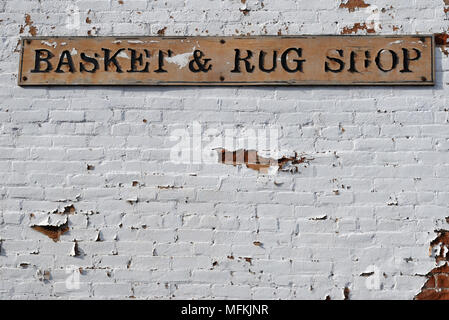 Ein Zeichen für einen Korb und Teppich Shop auf einem weiß getünchten Mauer in der Altstadt von Albuquerque, New Mexico hängt. Stockfoto