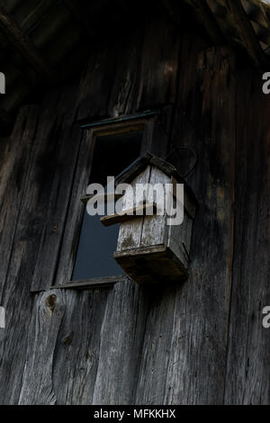 Sehr alten grauen Nistkasten aufhängen auf dem hölzernen graue Scheune Wand Stockfoto