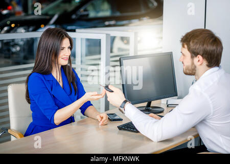 Zuversichtlich Verkäufer übergibt Autoschlüssel auf die weiblichen Kunden Abschluss profitabler Deal Stockfoto