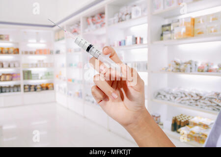 Hände die Ärzte das Füllen einer Spritze auf store Medizin und Pharmazie Apotheke für Hintergrund Stockfoto