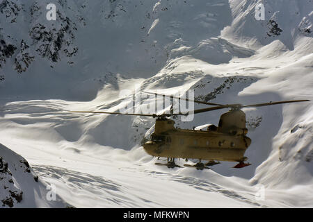 Ein CH-47F Chinook Hubschrauber von B-Company, 1 Battalion, 52nd Aviation Regiment fliegt durch die Alaska Range April 22, 2018. Flieger aus dem Zucker trägt einen Assist, um die National Park Service durch das fliegen tausende von Pfund an Ausrüstung und Versorgung von Talkeetna an den NPS base camp an der 7.000-Fuß-Niveau der Kahiltna-gletscher in der Vorbereitung für die Saison 2018 Denali klettern. (Armee Foto/John pennell) Stockfoto