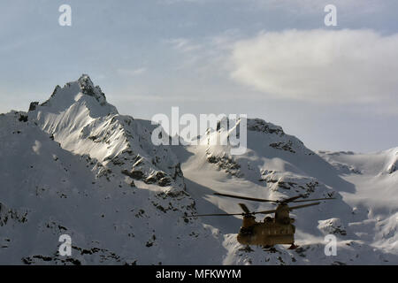 Ein CH-47F Chinook Hubschrauber von B-Company, 1 Battalion, 52nd Aviation Regiment fliegt durch die Alaska Range April 22, 2018. Flieger aus dem Zucker trägt einen Assist, um die National Park Service durch das fliegen tausende von Pfund an Ausrüstung und Versorgung von Talkeetna an den NPS base camp an der 7.000-Fuß-Niveau der Kahiltna-gletscher in der Vorbereitung für die Saison 2018 Denali klettern. (Armee Foto/John pennell) Stockfoto