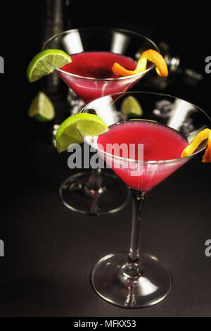 Alkohol cocktail Cosmopolitan mit Kalk auf schwarzem Hintergrund Stockfoto