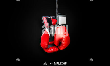 Scharlachrot boxing Mitts in einem dunklen schwarzen Hintergrund hängenden Stockfoto