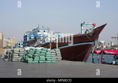 Dubai, Vereinigte Arabische Emirate - März 24., 2018. Die Rückseite der Seehafen. Eine kleine private no name Handelsschiff leert Taschen mit Baumwolle auf dem b Stockfoto