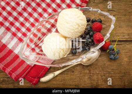 Vanilleeis in Glasschale mit Himbeeren und Blaubeeren, Vögel anzeigen Stockfoto
