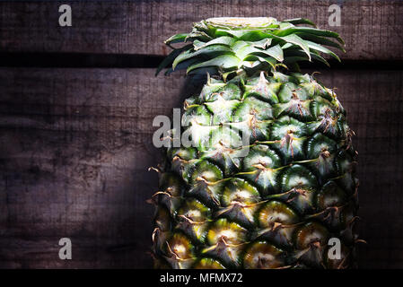 Ananas auf Holz Hintergrund mit Sonnenlicht aus dem Fenster Stockfoto