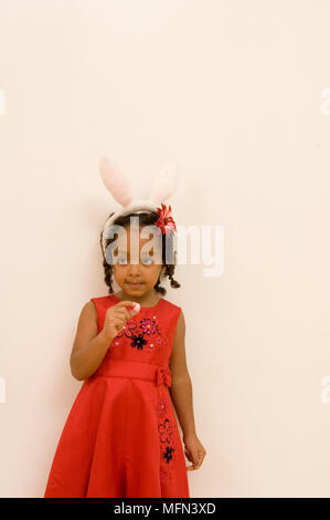 Nahaufnahme eines Mädchen, dass Candy in Osterhase Stirnband Ref: Obligatorische Gutschrift: Stockfoto