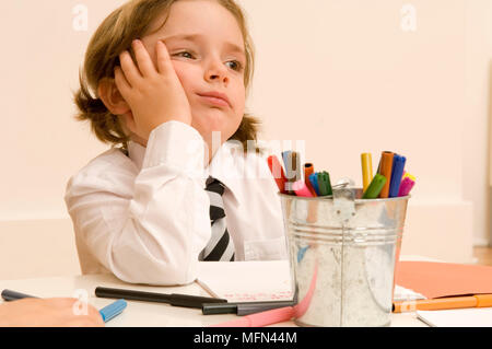Close-up von einem Mädchen, das an einem Tisch sitzen und Wegsehen Ref: Obligatorische Gutschrift: Stockfoto