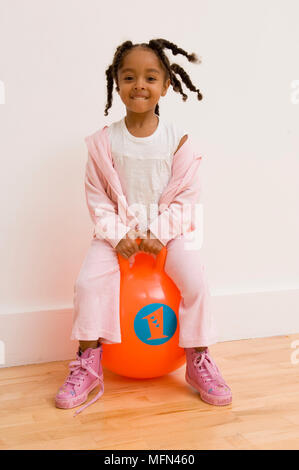 Portrait eines Mädchen sitzt auf einem Space Hopper Ref: Obligatorische Gutschrift: Stockfoto