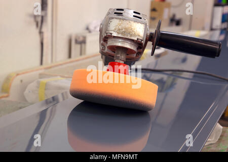 Electric Industrial Puffer mit Schaumstoffkopf reflested auf ein lackiertes Blech in einem Workshop Stockfoto