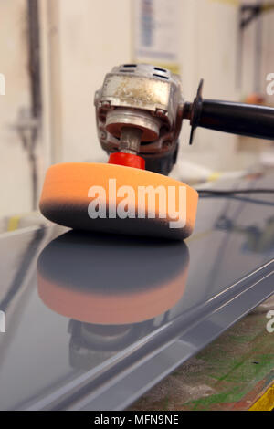 Electric Industrial Puffer mit Schaumstoffkopf reflested auf ein lackiertes Blech in einem Workshop Stockfoto