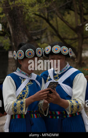 Lijiang, China - 23. März 2018: Chinesische Frauen das Tragen eines traditionellen Bai Minderheit Kleidung mit einem Smartphone in Lijiang, Yunnan Stockfoto