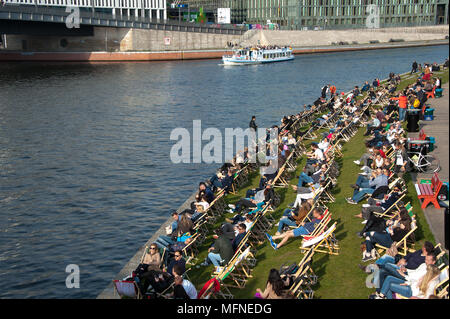 Berlin, Deutschland: Eine typische warme Wetter Zeitvertreib - Menschen entspannen Sie in Liegestühlen am Ufer der Spree, an einem sonnigen Tag. Stockfoto