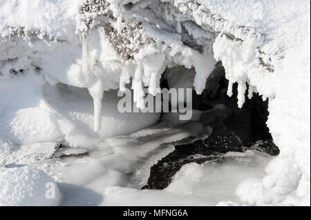 Eiszapfen Form auf natürliche Felsen Brücke zu Schwarz fließendes Wasser - Wasserfall Godafoss, Island Stockfoto