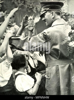 Adolf Hitler begrüßt Masse während eines Besuchs in einer deutschen Stadt, c1938. Stockfoto