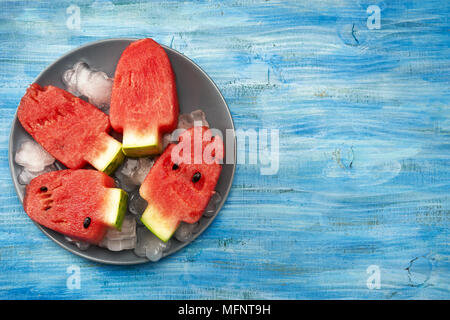 Wassermelone Stücke schneiden in Eis Lolly Pop Form auf hellen blauen Hintergrund Stockfoto