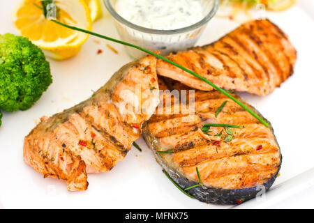 Steaks von Lachs, gegrillt. Mit Gemüse und Gewürze auf dem weißen Teller serviert Stockfoto