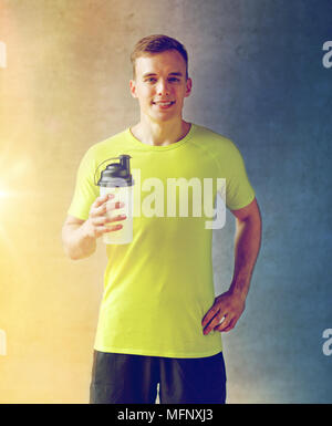 lächelnder Mann mit Protein Shake Flasche Stockfoto