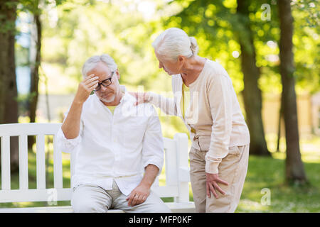 Ältere Menschen leiden unter Kopfschmerzen im Freien Stockfoto