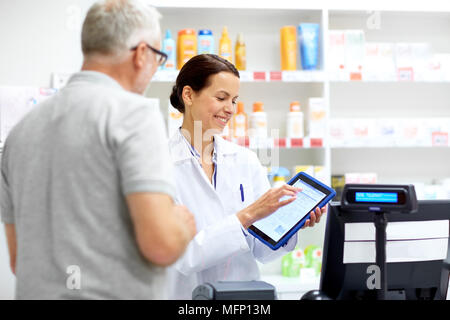 Apotheke und Kunden mit Tablet-PC in der Apotheke Stockfoto