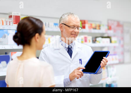 Apotheke und Kunden mit Tablet-PC in der Apotheke Stockfoto