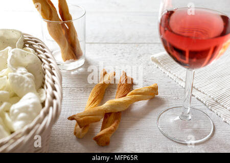 Glas Rose Wein mit herzhaften Snacks Party auf rustikalen weiße Holztisch. Stockfoto