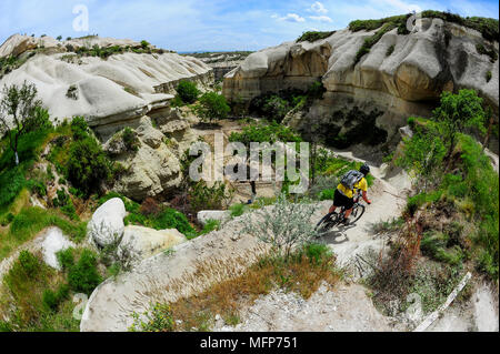 Ein Mann reitet ein Mountainbike auf einem Trail in einem Canyon in Kappadokien, Türkei. Stockfoto