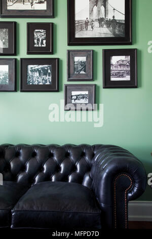 Anordnung der Fotos oben Leder Chesterfield Sofa in grün Studie, New York, USA Stockfoto