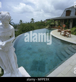 Ein Außenpool mit einer antiken Statue im Vordergrund. Stockfoto