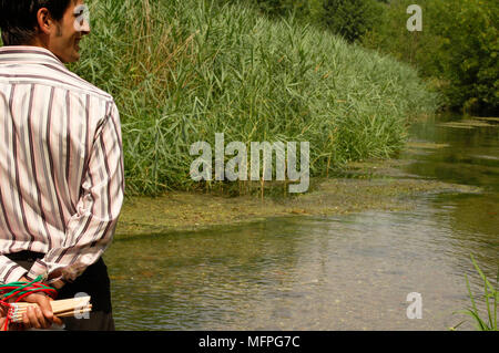 Rückansicht eines jungen Mannes in der Nähe von einem Fluß mit seinen Händen hinter seinem Rücken Ref: CRUSC 10015 019 obligatorische Credit: Stuart Cox/Photoshot gebunden Stockfoto