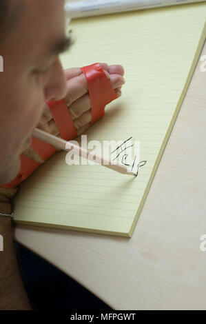 Nahaufnahme eines Mannes schreiben auf einen Notizblock und einen Stift im Mund Ref: CRUSC 10020 004 obligatorische Credit: Staurt Cox/Photoshot Stockfoto